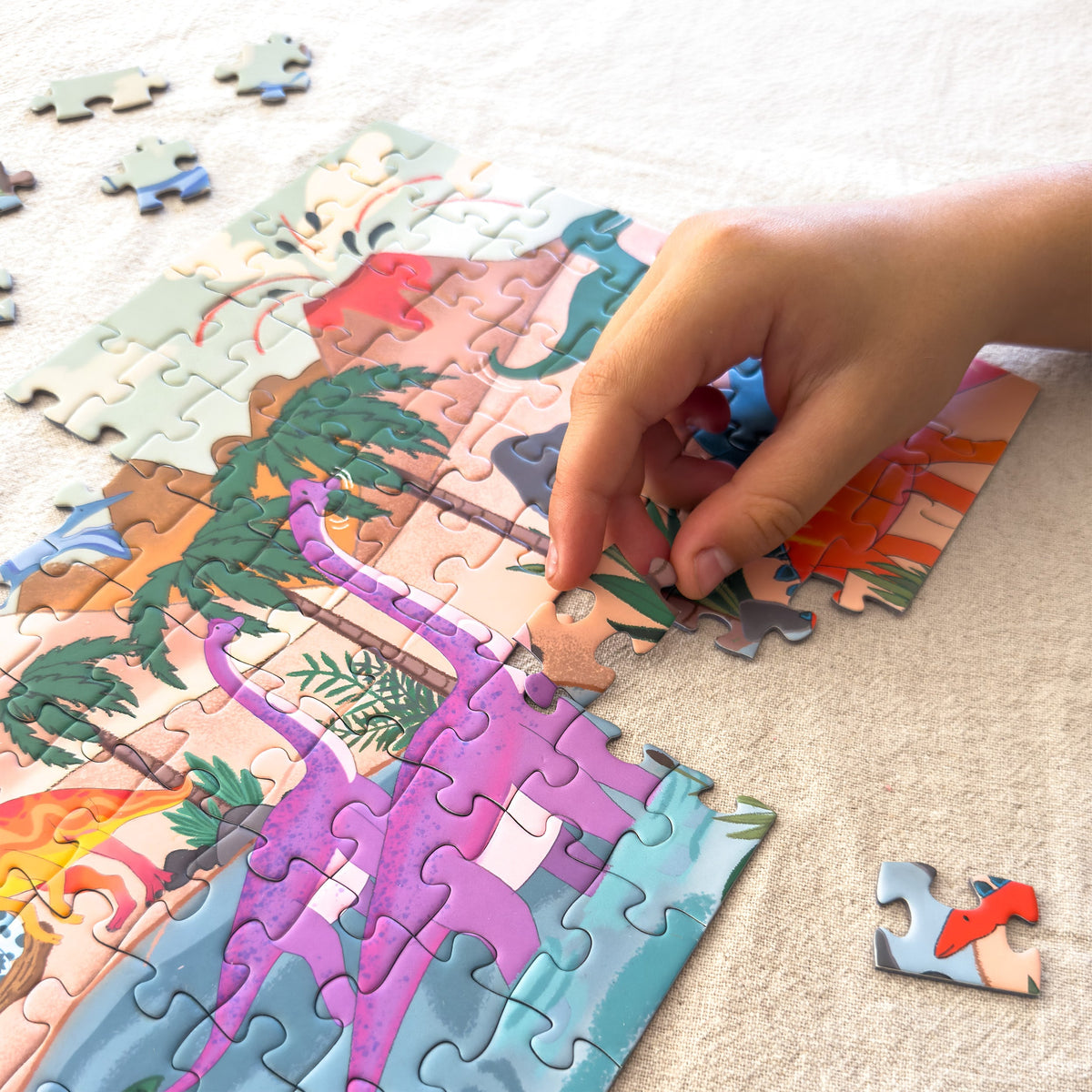 Child fitting pieces into the Dinosaur World 100-piece jigsaw