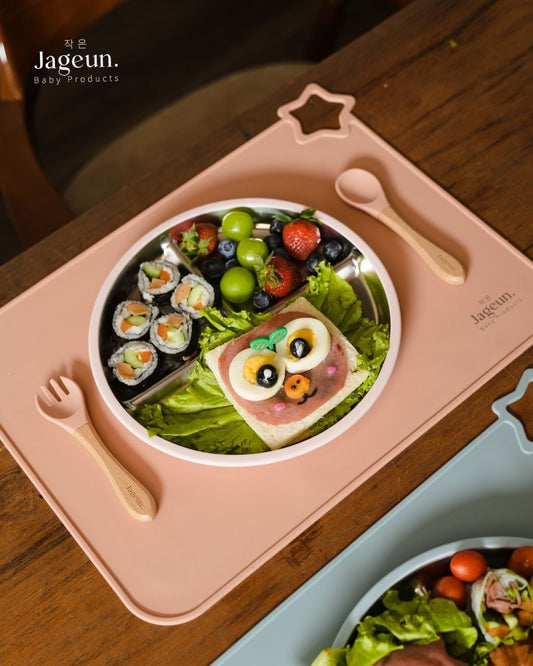 Jageun stainless steel divided plate with sushi and salad on a pink placemat