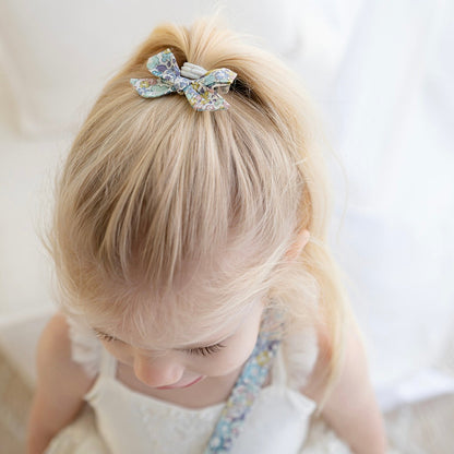 Girl wearing the Suzanne petite bow clip