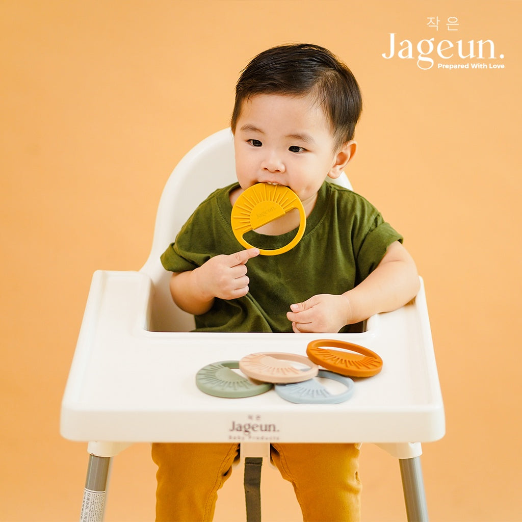 Baby chewing on a silicone sun teether
