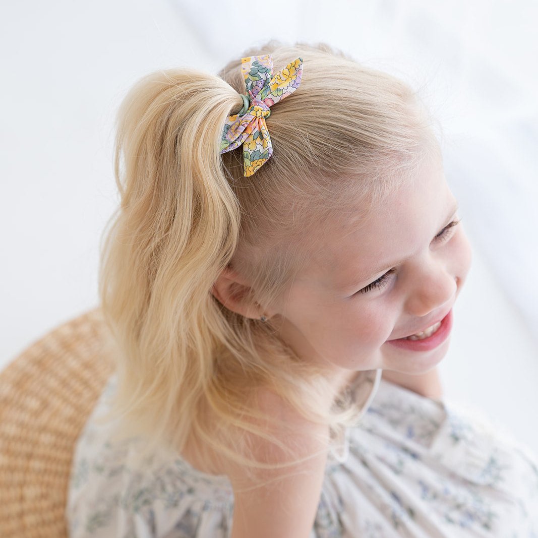 Girl wearing the Audrey petite bow clip in her ponytail