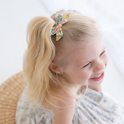 Girl wearing the Audrey petite bow clip in her ponytail