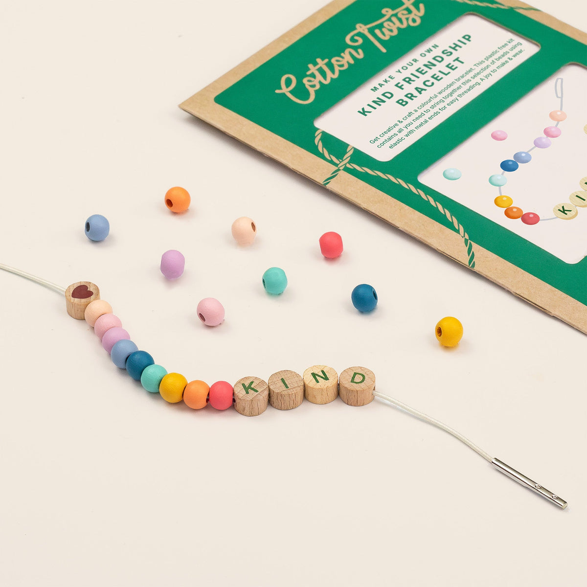 Threading KIND letter beads onto a friendship bracelet