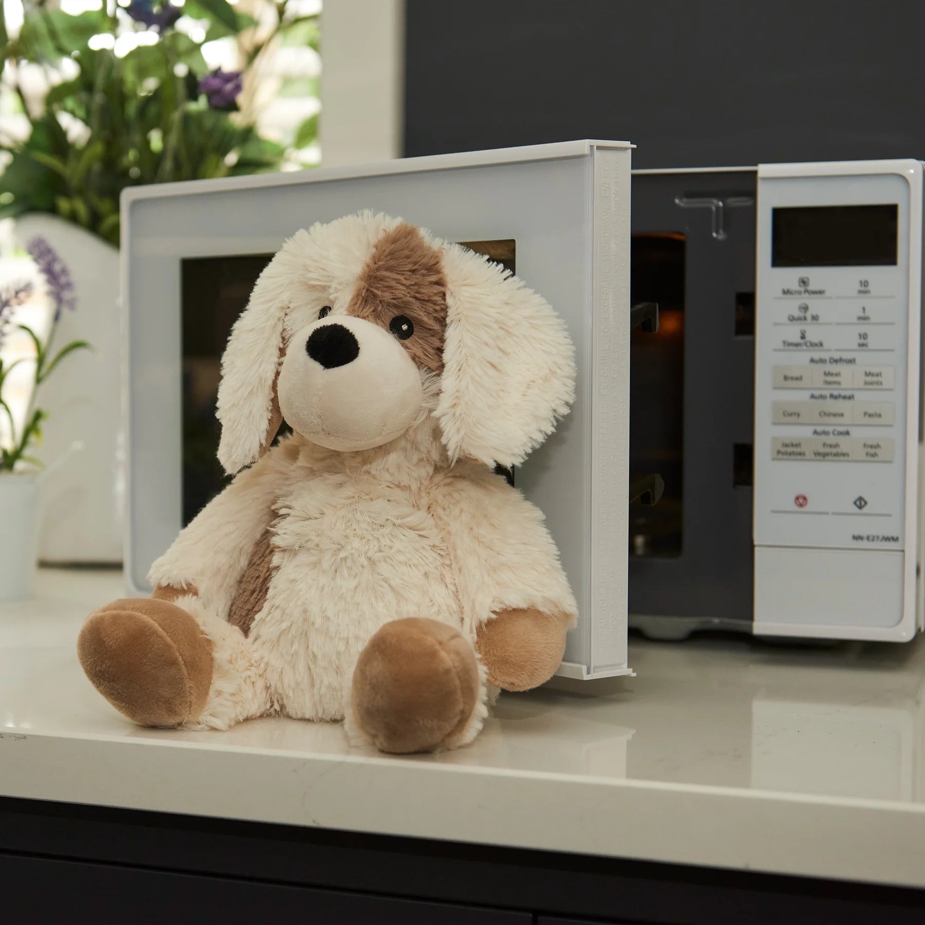 Warmies Junior puppy lavender plush toy beside a microwave