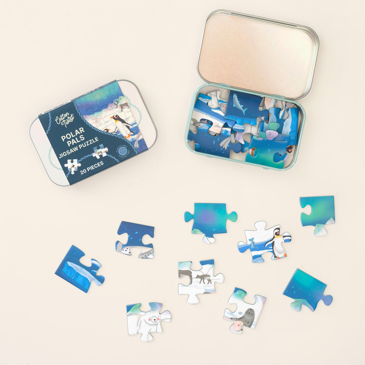 Polar Pals mini jigsaw pieces laid out beside the open tin