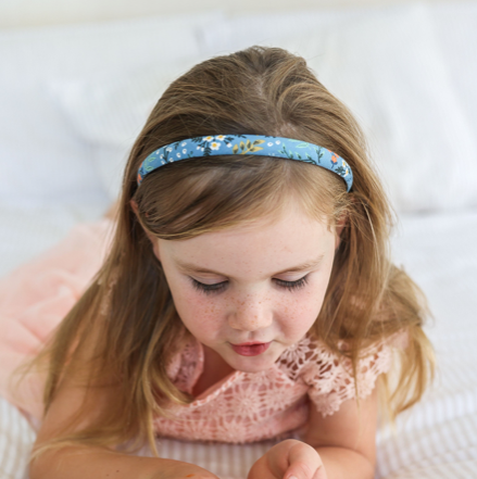 Girl resting her chin on her hands wearing the Bethany Alice headband