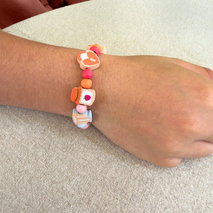 Child wearing a bracelet made with the Cotton Twist Tiny Trinkets Beading Kit