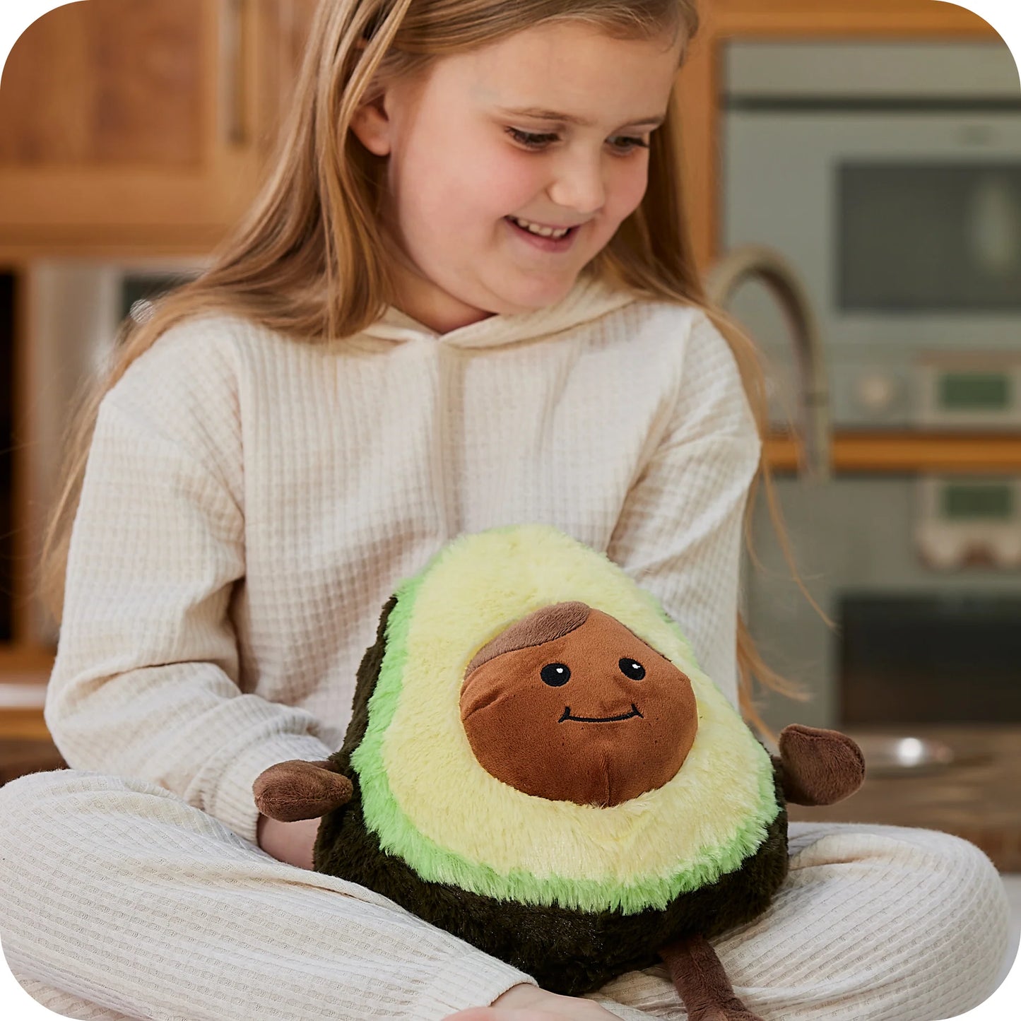 Child holding a Warmies avocado microwavable lavender plush toy