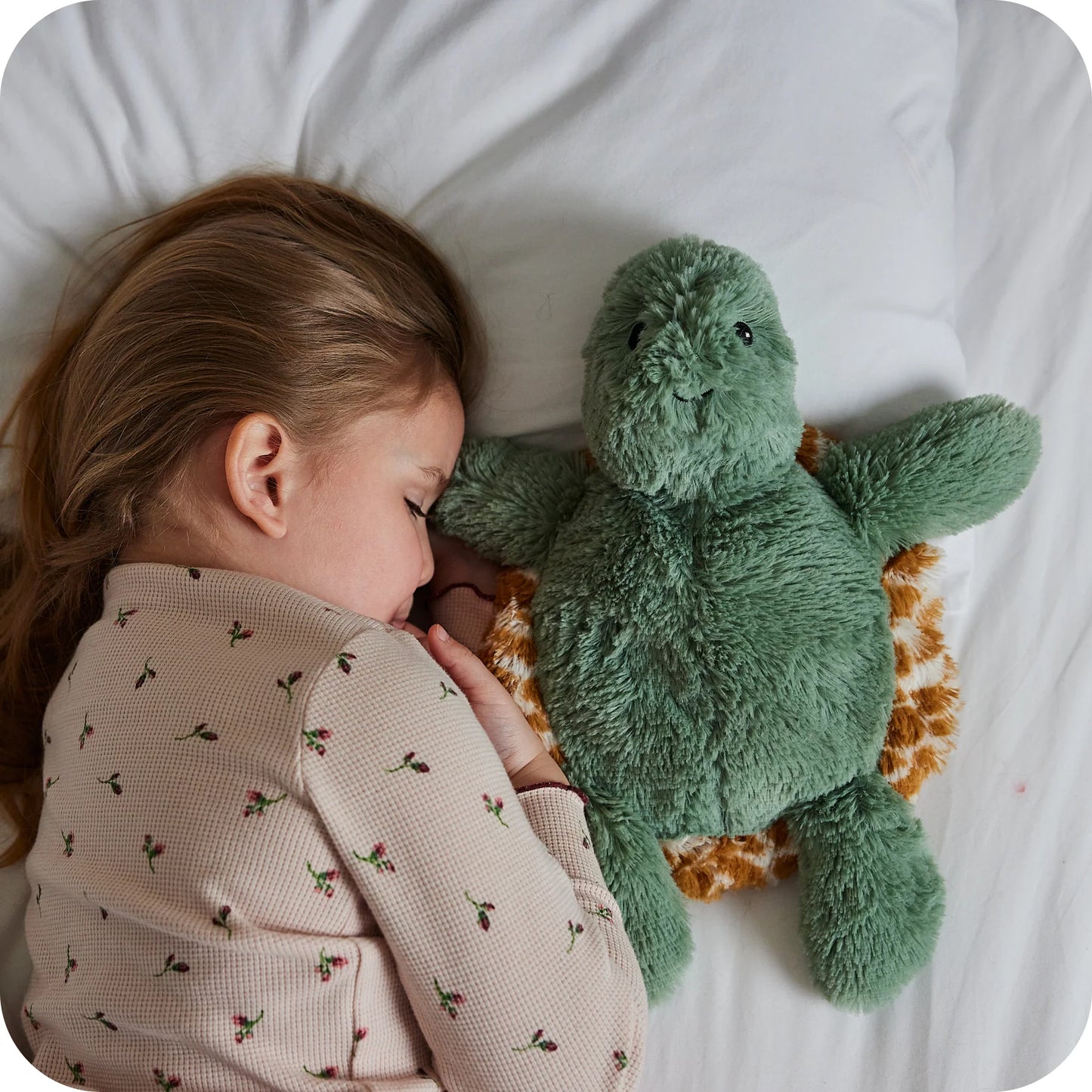 Child sleeping beside a Warmies Mini Turtle microwavable lavender plush toy