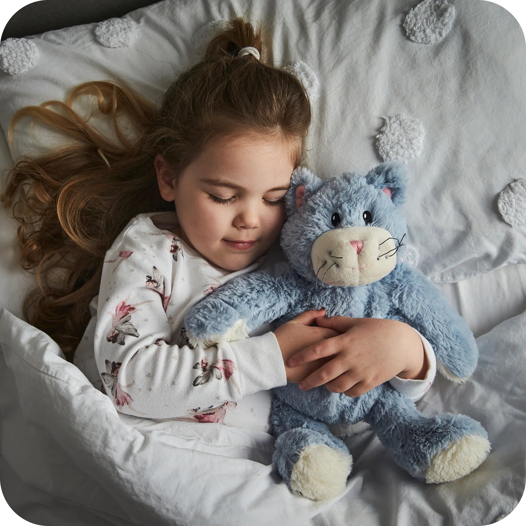 Child asleep hugging a Warmies blue cat heatable lavender plush toy