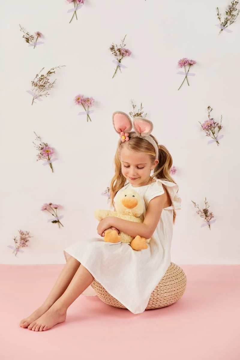 Child holding a Warmies chick microwavable lavender-scented plush toy
