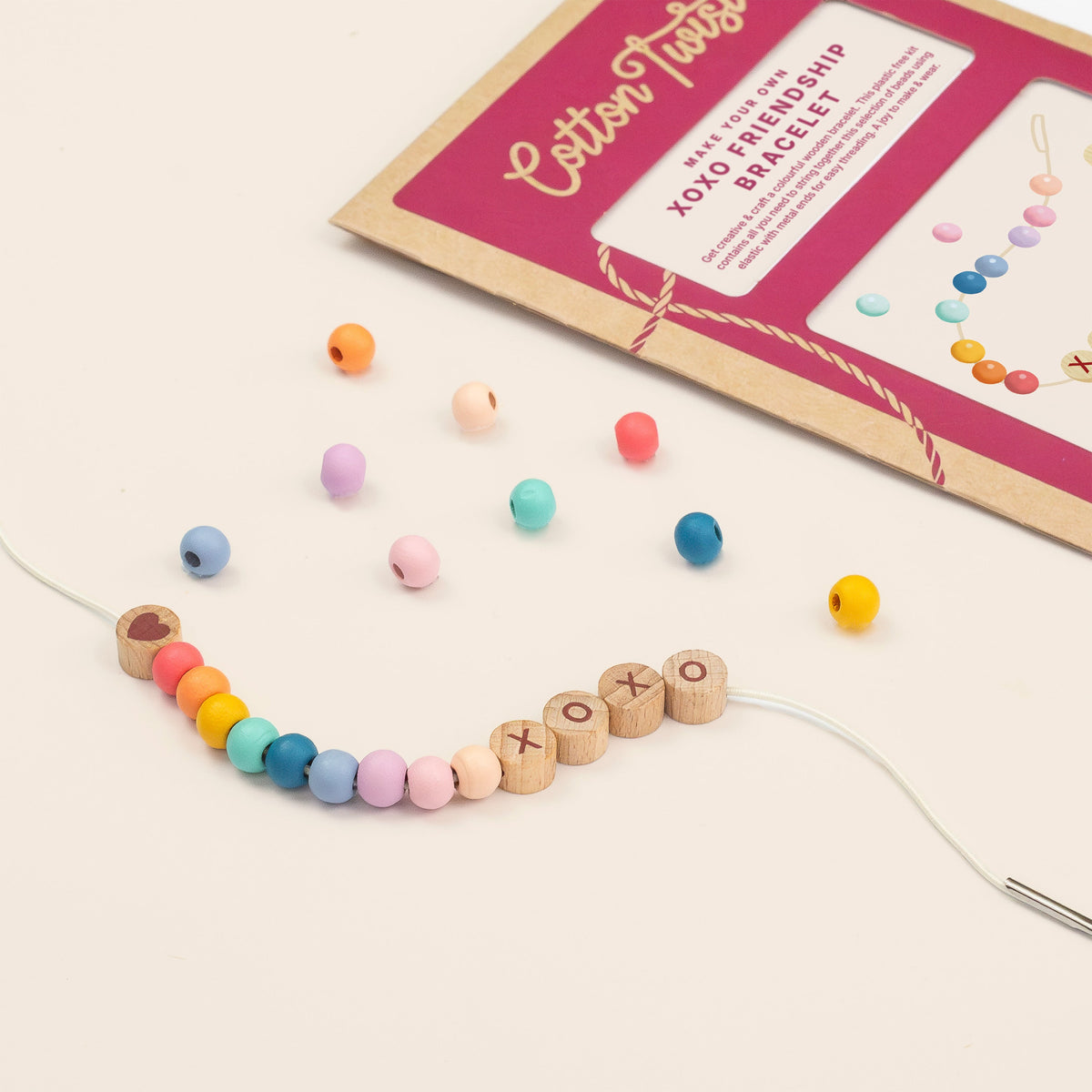 Threading XOXO letter beads onto a friendship bracelet