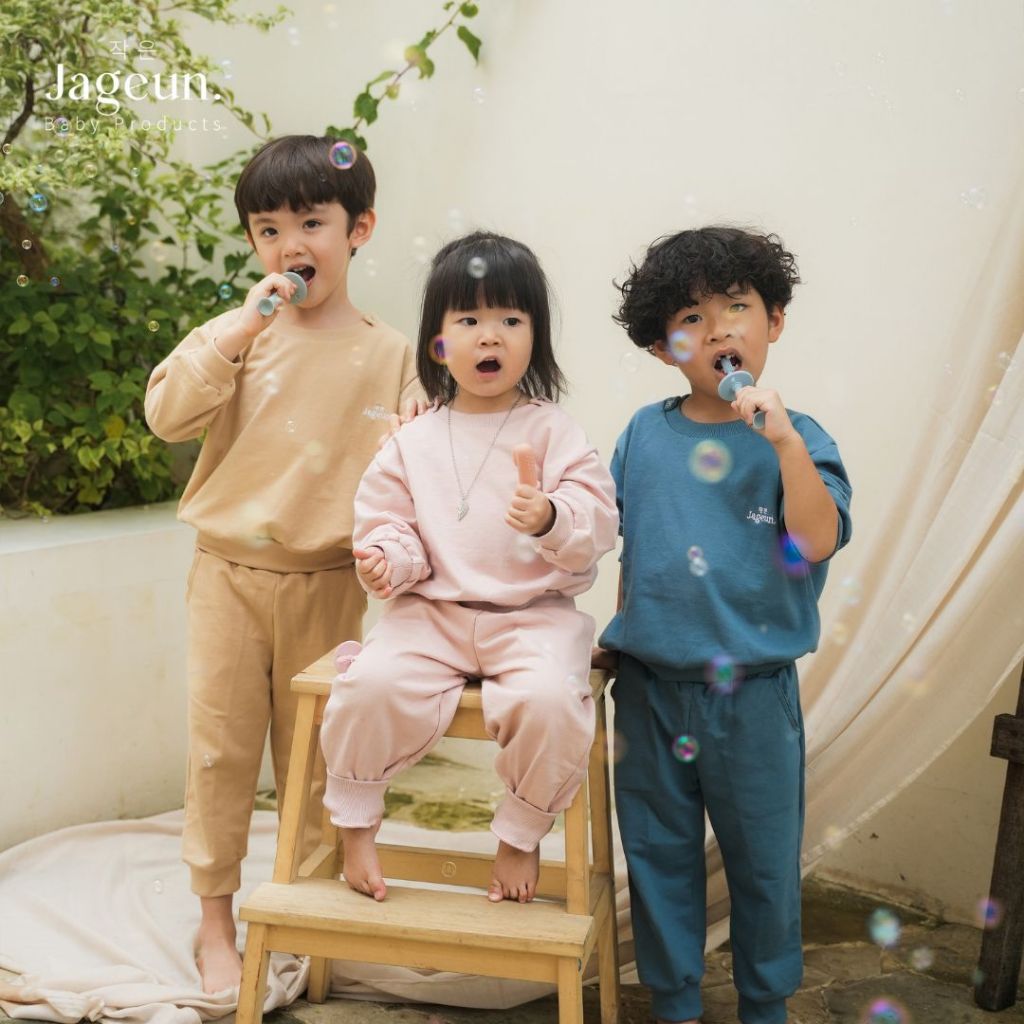Three children using Jageun training toothbrushes