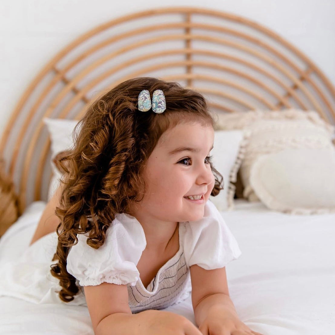 Smiling girl with curly hair wearing Josie Joan's Suzanne hair clips